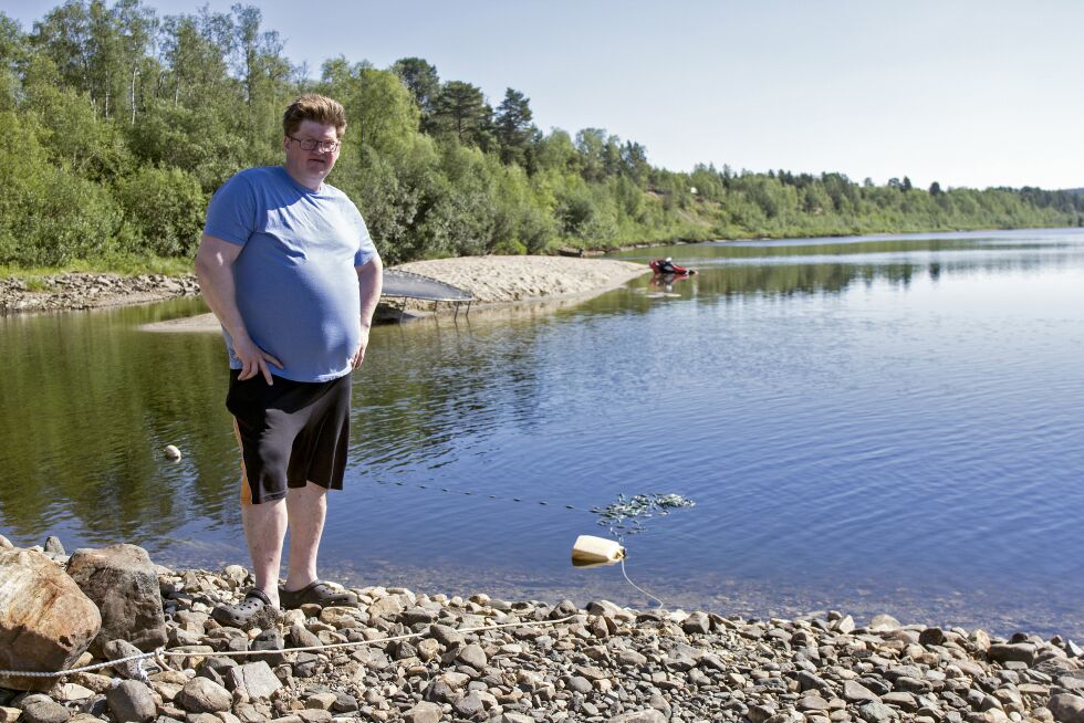 Her står Hans Jørgen ved garnstedet sitt, garnet er krøllet sammen ved vannkanten. I bakgrunnen kan vi se en vannskuter som ligger i vannet, og en trampoline som stadig er i bruk.
 Foto: June Helén Bjørnback