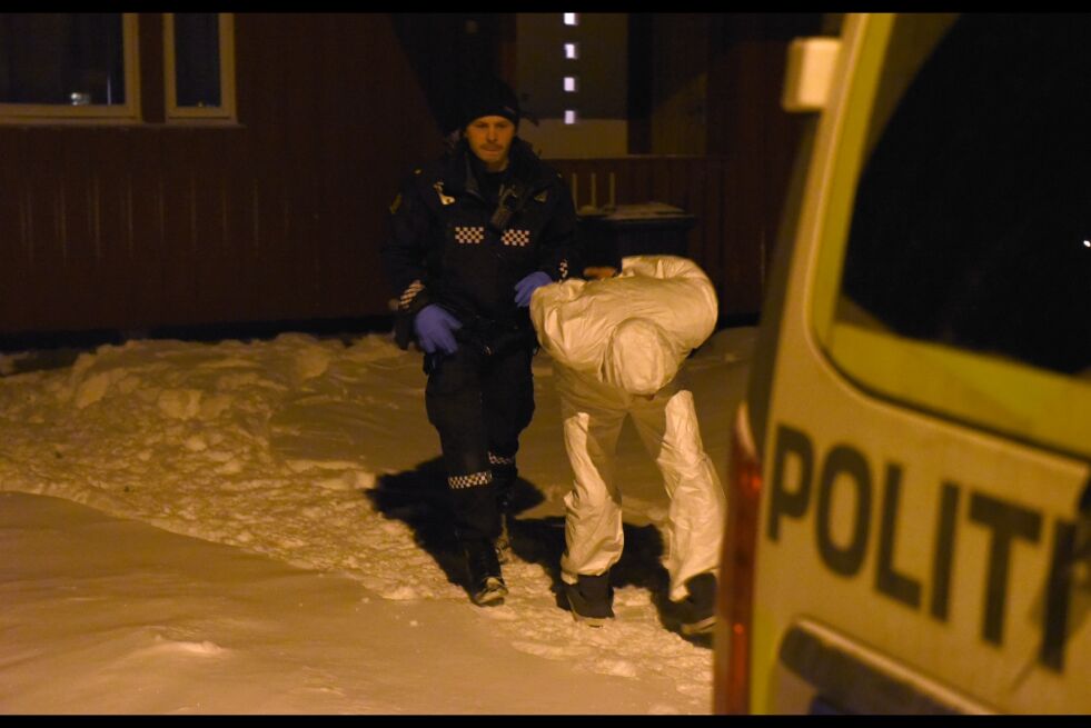 En person ikledd hvit kjeledress ble tirsdag ettermiddag brakt ut av boligen i håndjern.
 Foto: Kristin Humstad