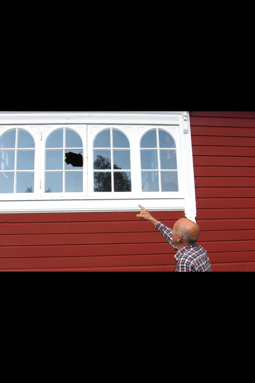 Harald Steinmo, som er kasserer i Neiden kirkeforening, viser at tyven(e) brøt seg inn gjennom et vindu på baksiden av kirka.
 Foto: Mari-Ann Nilssen