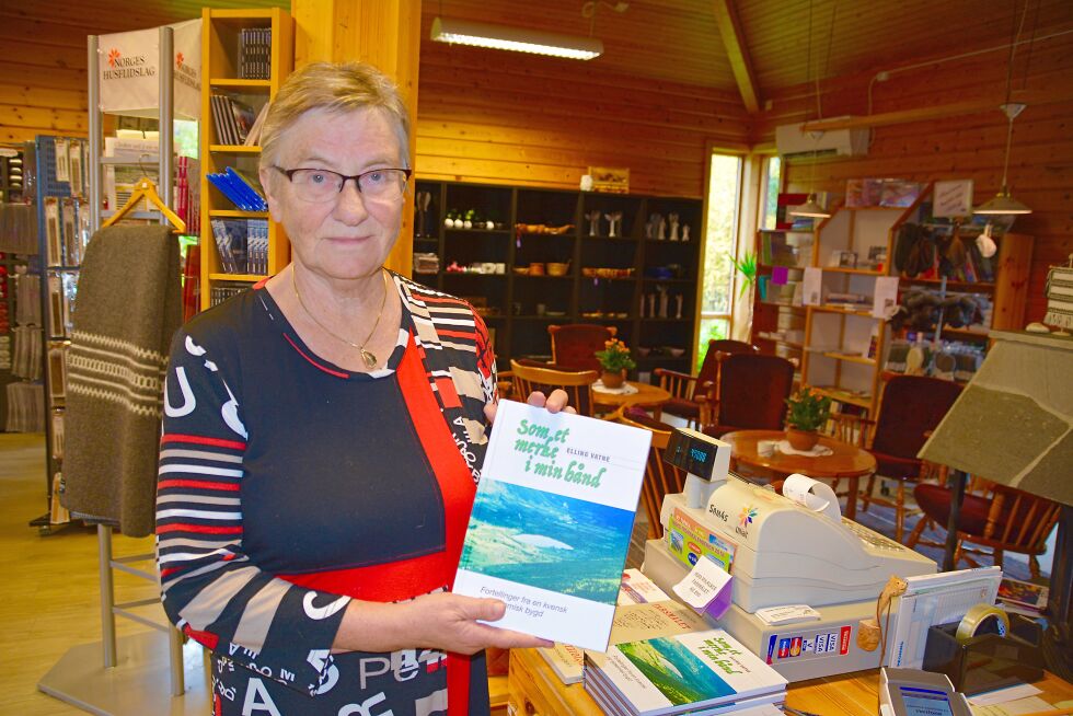 Leder av Husfliden i Manndalen, Gunn Isaksen viser frem Elling Vatnes bok «Som et merke i min hånd - Fortellinger fra en kvensk og sjøsamisk bygd».
 Foto: Elin Margrethe Wersland