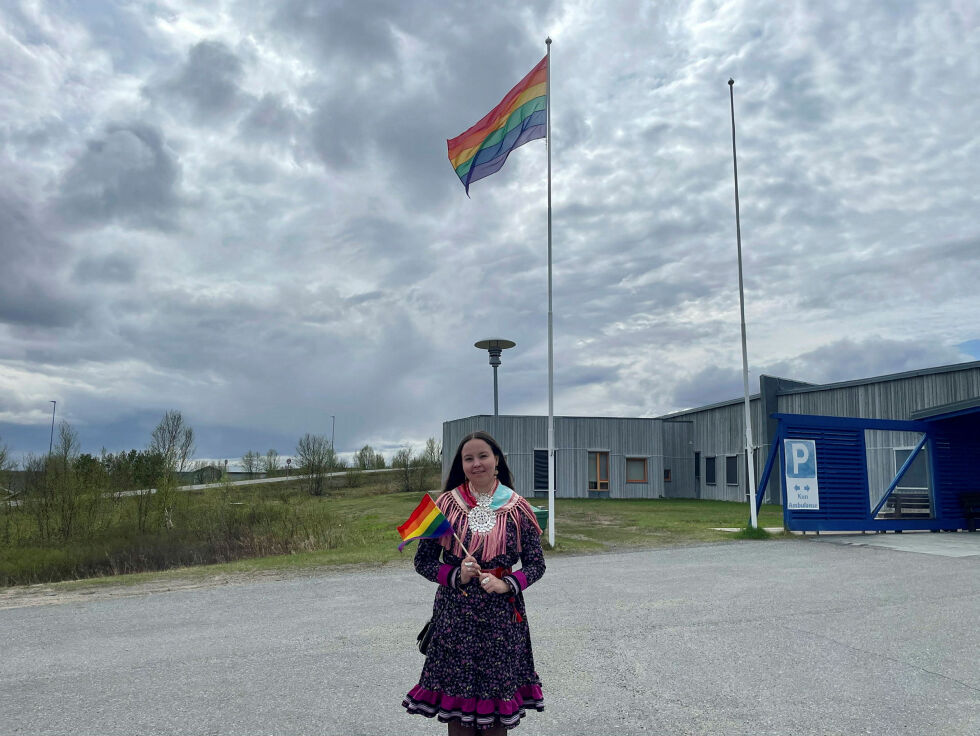 Varaordfører Elle Mári Dunfjell Oskal med inkluderingsflagg foran Kautokeino helsesenter. 
– Det er veldig gledelig! At man viser aksept og respekt, sier hun.
 Foto: Privat