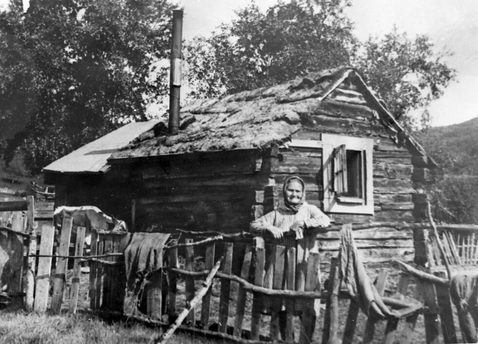 Kaia Magga Ram utenfor den lille tømmerstua hun bodde i mesteparten av livet.
 Foto: Utlånt av Grenselandmuseet