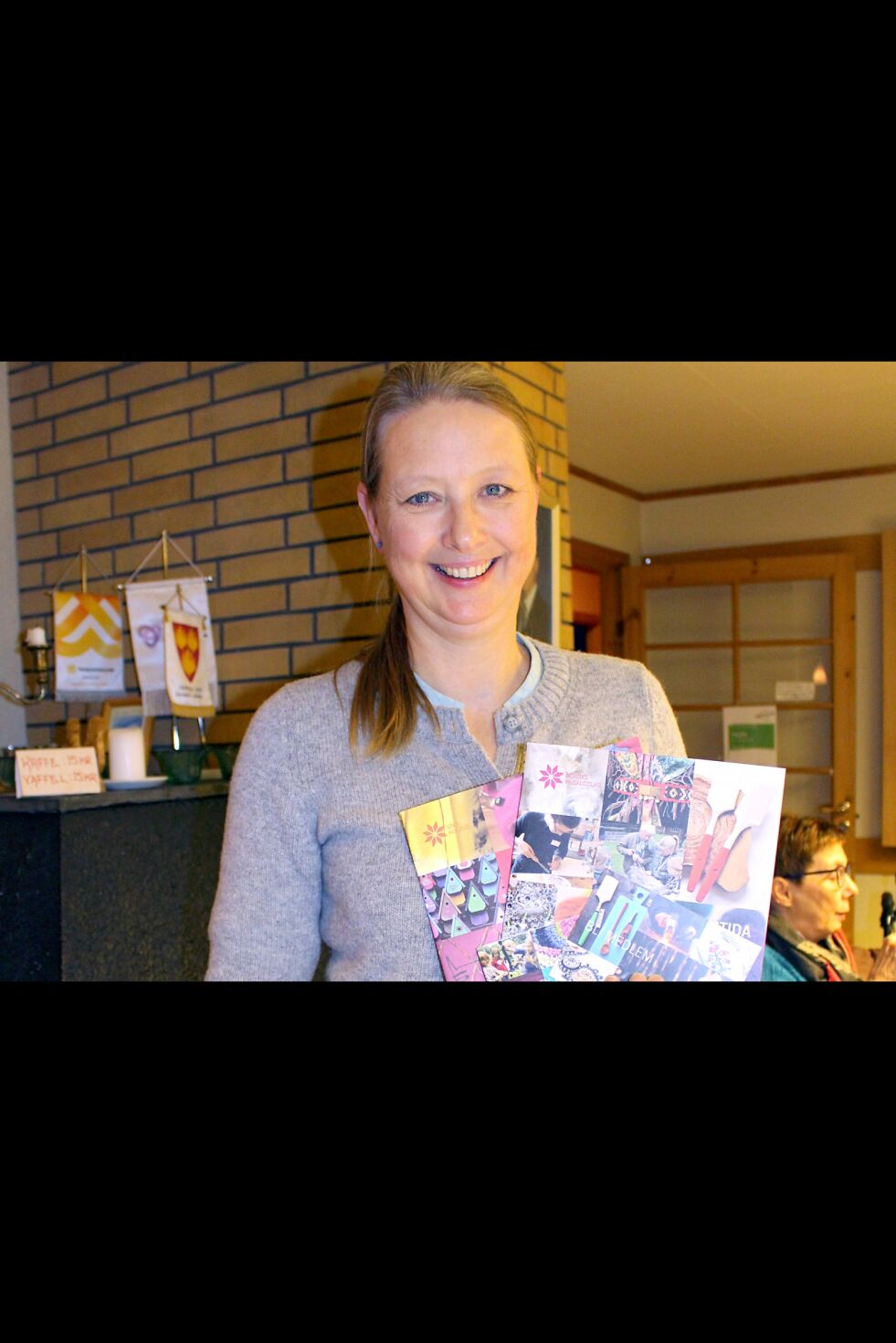Maaike Dirkje Halbertsma holder fem vervemateriell og hefter med informasjon om Norges husflidslag.
 Foto: Elise Embla Scheele