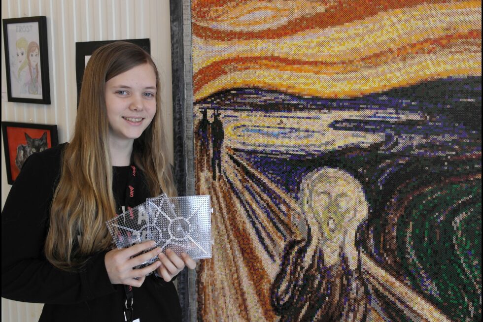Elin Osmark Kristiansen (14) fra Evenes viser stolt fram sitt verk «Skriket 43.200 perler». Kunstverket er 90 cm bredt og 120 cm høyt. Det er satt sammen bit for bit ved hjelp av 48 perlebrett av den typen hun viser. For å få det til måtte hun tenke speilvendt, for limpapiret legges på toppen av perlene før brettet snus. Elin forteller til Ságat at hun brukte til sammen 96 timer på verket. Det tilsvarer fire døgn eller 16 hele skoledager.
 Foto: Steinar Solaas