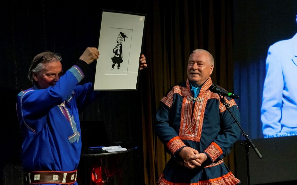 Kautokeino-ordføreren Hans Isak Olsen (til høyre) overrakte en gave til 40-årsjubilanten Beaivváš, i form av et kunstverk. Teatersjef Rolf Degerlund tok imot gaven på vegne av teateret, i forbindelse med markeringen av 40-årsjubileet.
Foto: Beaivváš/Aslak Mikal Mienna