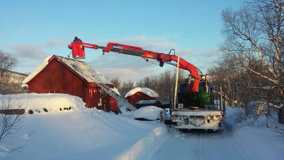 Tak­et på Gjed­de­vann vann­verk i Rus­te­fjel­bma måt­te bli løf­tet av for å få satt de nye tan­ke­ne på plass. Ole Muo­sat i fir­ma­et Sami House fra Bo­na­kas gjør jobb­en.
 Foto: Tom Hardy