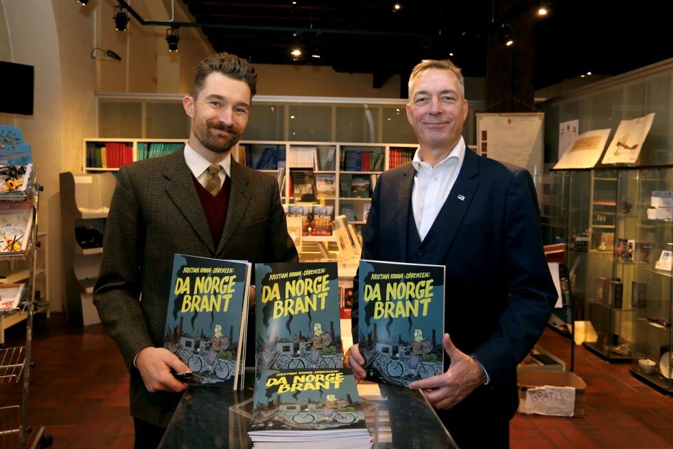 Forsvarsminister Frank Bakke-Jensen (til høyre), med en signert utgave av tegneserien han synes er viktig krigshistorie fortalt på en spennende måte. Her sammen med tegneserieskaper Kristian Krohg-Sørensen.
 Foto: Asgeir Spange Brekke/ Forsvarsdepartementet