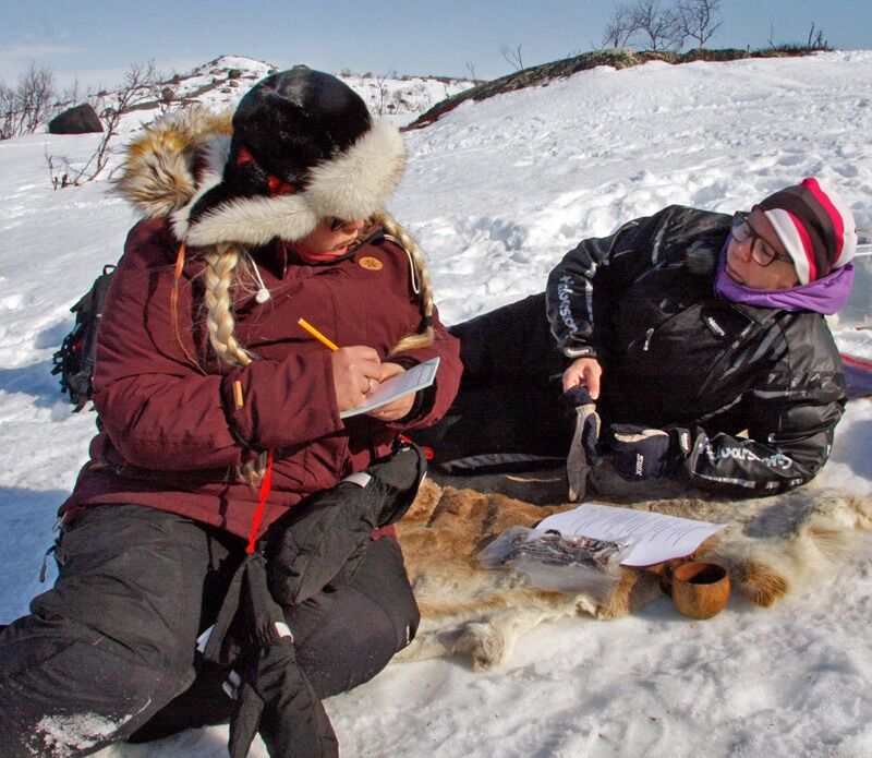 Hanne Iversen får hjelp av Heidi Jernsletten til å løse en samisk-quiz på folkevalgtopplæring i samisk i Nesseby kommune.
 Foto:  Bent Johansen