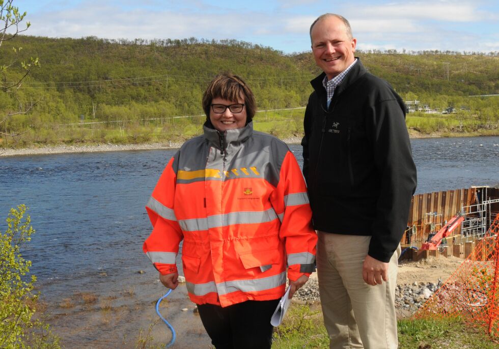 Fornøyd minister: Avdelingsdirektør Oddbjørg Mikkelsen i Statens vegvesen Finnmark (til venstre) ga samferdselminister Ketil Solvik-Olsen orientering om fremgangen i byggingen av ny bru over Tanaelva. Solvik-Olsen var meget fornøyd med det han så. I bakgrunnen er fundamentet til hovedtårnet under bygging.
 Foto: Tom Hardy