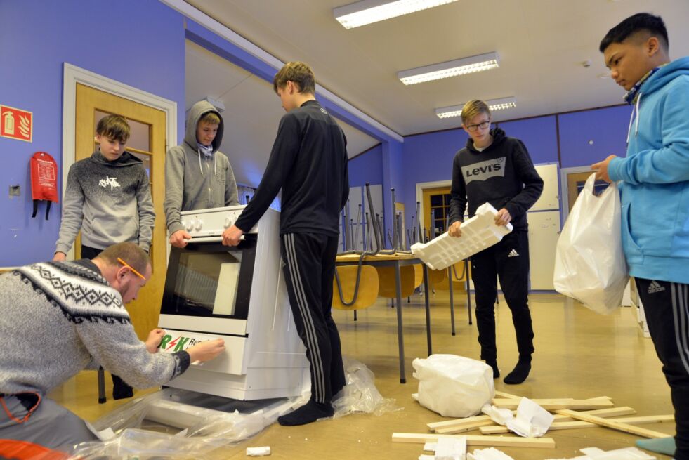 Ungdomsbedriften BSO Mat Kraft er så takknemlig for at de får bruke skolekjøkkenet gratis at de valgte bare halv driftstøtte fra sponsoren for å få en ny komfyr som de gir til skolen. Onsdag ble komfyren pakket ut av (stående fra venstre) Anton Hansen, David Johannessen, Joakim Samuel Andersen, Sigurd Eliassen og Mark Srisurat. Elevene Yngve Johannessen og Suwisa Srisurat var ikke til stede da bildet ble tatt. På golvet foran komfyren sitter prosjektansvarlig Raimond Akselsen og limer på sponsorreklame.
 Foto: Sonja E. Andersen