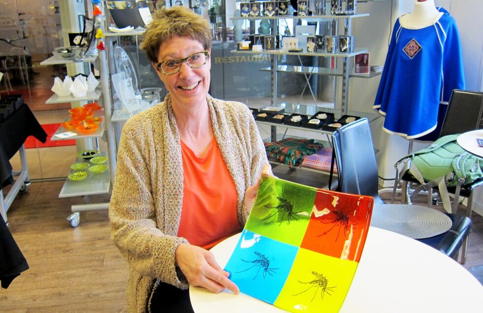 Daniela Salathe viser frem mygg-dekorert glasskunst. Sammen med Dieter Salathe driver hun Arctic glasstudio i Berlevåg, og er glad for å kunne selge og markedsføre seg under Borealis-festivalen i Alta.
 Foto: Rita Heitmann