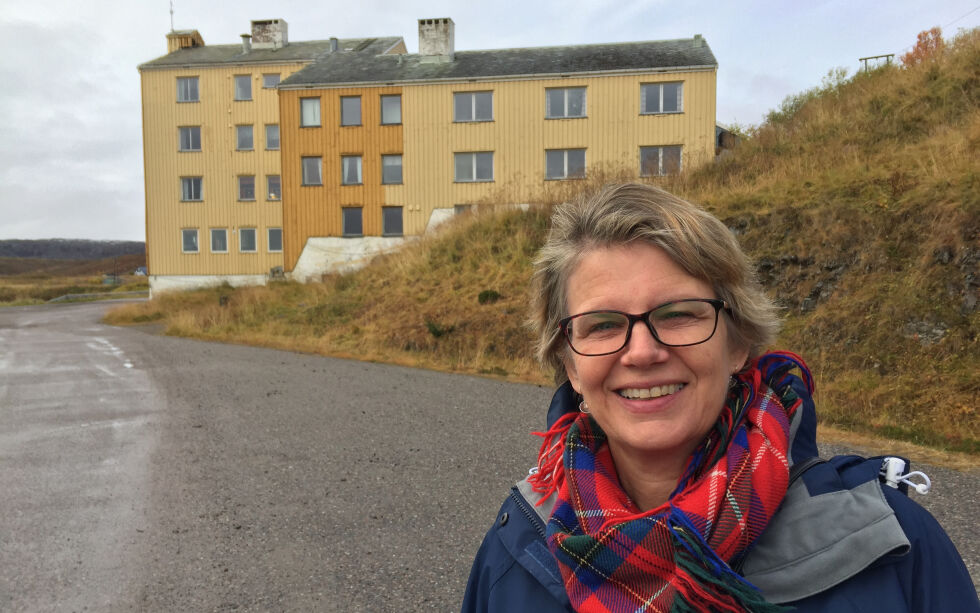 Forfatter og tidligere journalist Ingjerd Tjelle skal igjen skrive bok om internatlivet i Finnmark. Her står hun foran et av de største internatene i Finnmark, Karlebotn internat i Nesseby.
 Foto: Privat
