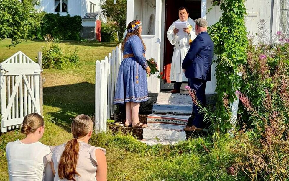 Sognepresten i Kåfjord, Richard Olsen Svane, vier Eline Petrine Johansen og Torgeir Larsen. Brudgommens døtre, Marita og Malin Guttormsen Larsen, sitter på benken foran posthustrappa på familiegården Djupvik.
 Foto: Elisabeth Salamonsen