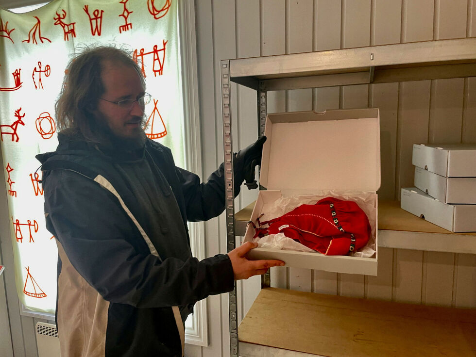 Samlingsforvalter Claus Pettersen åpner en av eskene med gjenstander som nå rømmer Polmak. Blant dem er mange tekstiler, som her en kvinnelue.
 Foto: Birgitte Wisur Olsen