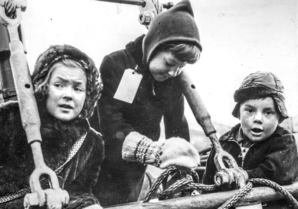 To jenter og en gutt merket med bagasjelapper hvor navnene er påskrevet.
 Foto: Riksarkivet