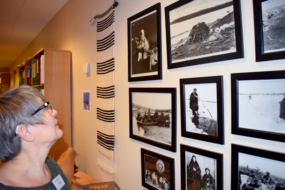 Venke Tørmænen inne på Ä´vv Skoltesamiske museum i Neiden. Hun ser opp på et bilde av oldemoren sin.
 Foto: Birgitte Wisur Olsen