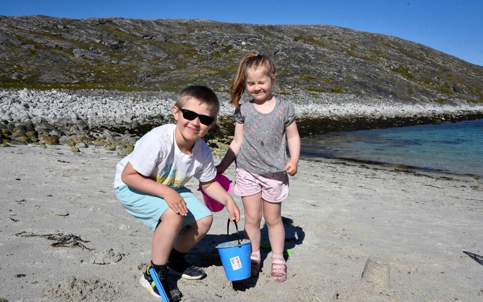 Adrian (7) og Saia (4,5) bygger sandslott, og går opp og ned til sjøen for å hente vann.
 Foto: Cecilie Ditløvsen
