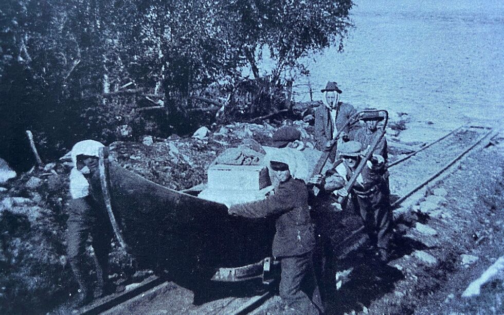 Den før­s­te tral­le­ba­nen i vass­dra­get ble bygd på Skog­foss i 1912. Her er det fire menn som drar opp en godt lasta båt i godt mygg­vær. Foto: Foto Edvardsen
