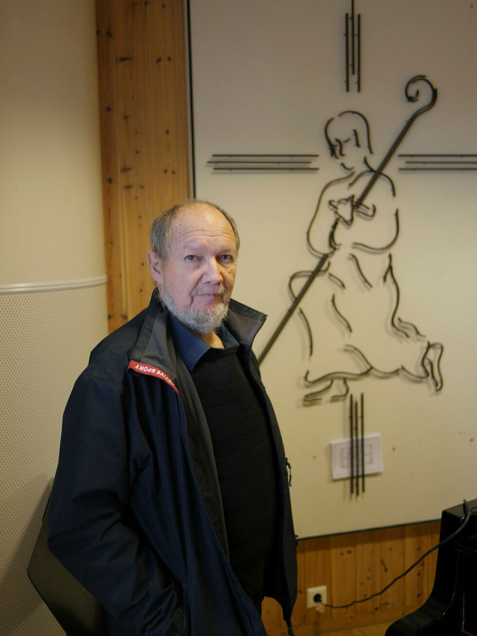 Gunnar Pettersen er godt fornøyd med at altertavla «Hyrden»; som hans onkel Per Petterson designet, nå har fått sin plass på veggen i menighetssalen.
 Foto: Geir Johansen