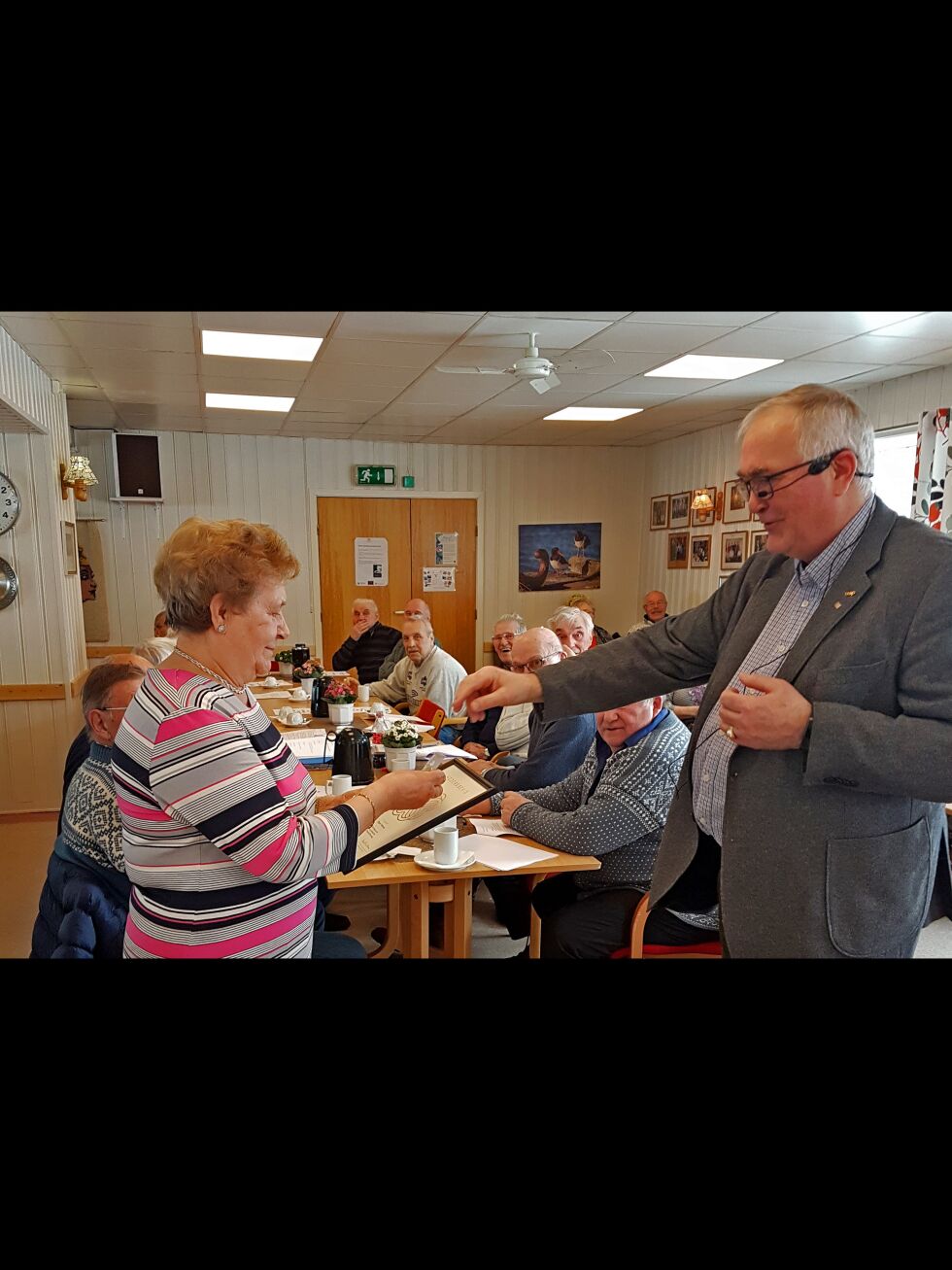 Her får Dagny Pedersen diplom og smykke av pensjonistforeninga i Kirkenes sin leder, Nils Edvard Olsen, for utrettelig innsats på kafeen og i en rekke komiteer gjennom årene i pensjonistforeninga.
 Foto: Privat