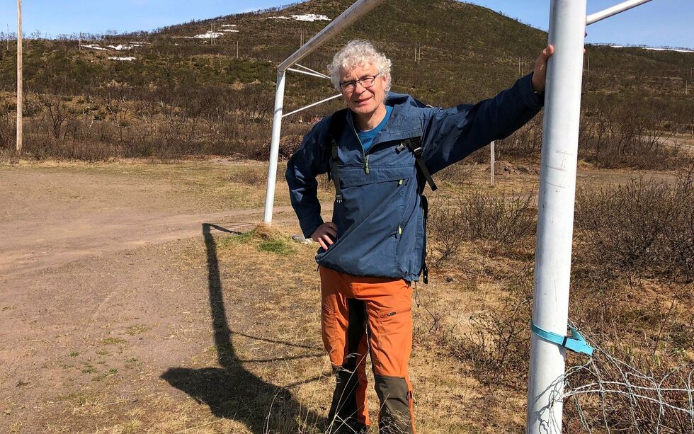 Trond Mag­ne Hen­rik­sen har på­tatt seg ans­var­et med å få ut et ju­bi­le­ums­hef­te når Finn­mark fot­ball­krets i år fei­rer 100 år. Her har han tatt plass på gam­le Mesk­elv sta­di­on i Nes­se­by, og hå­per å få inn gode his­to­ri­er også der­fra. Foto: Pri­vat