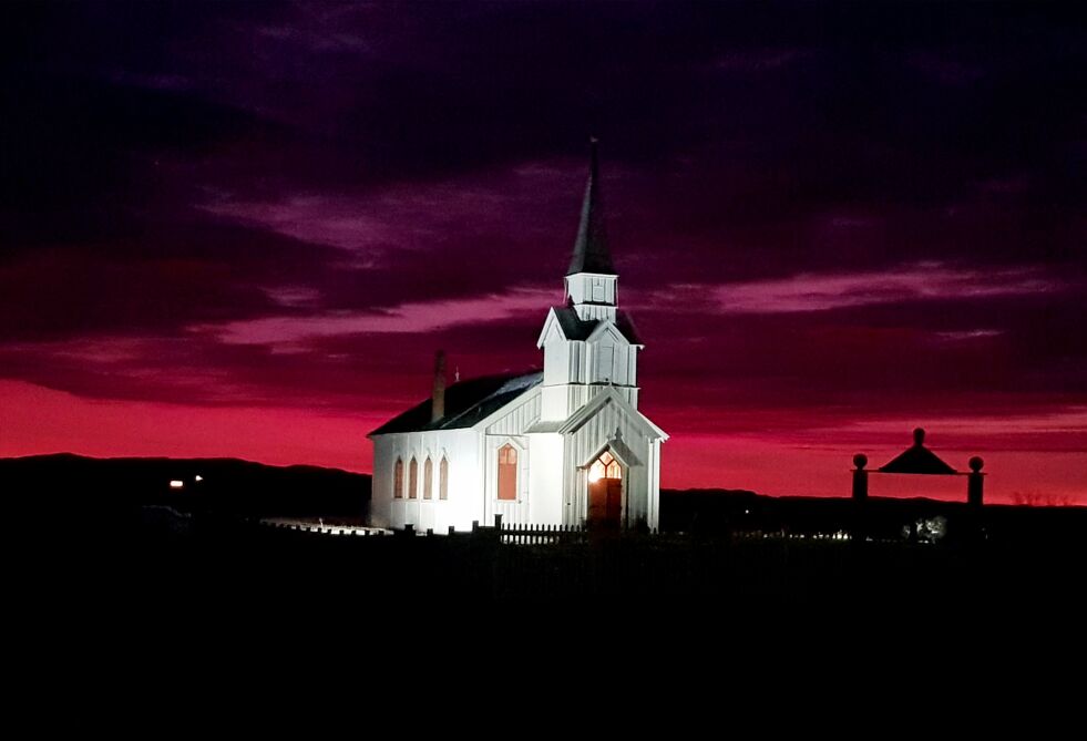 I helga fremsto Nesseby kirke i sin flotteste prakt med en brennende himmel som nydelig ramme rundt seg.
 Foto: Tanja Therese Haugen