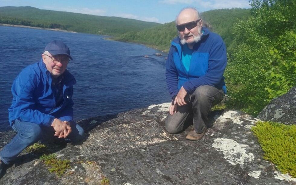 Odd Tobiassen og Wilhelm Andersen ved et mer eller mindre overgrodd grensemerke på norsk side av Tanaelva.
 Foto: Asbjørn Rolstad
