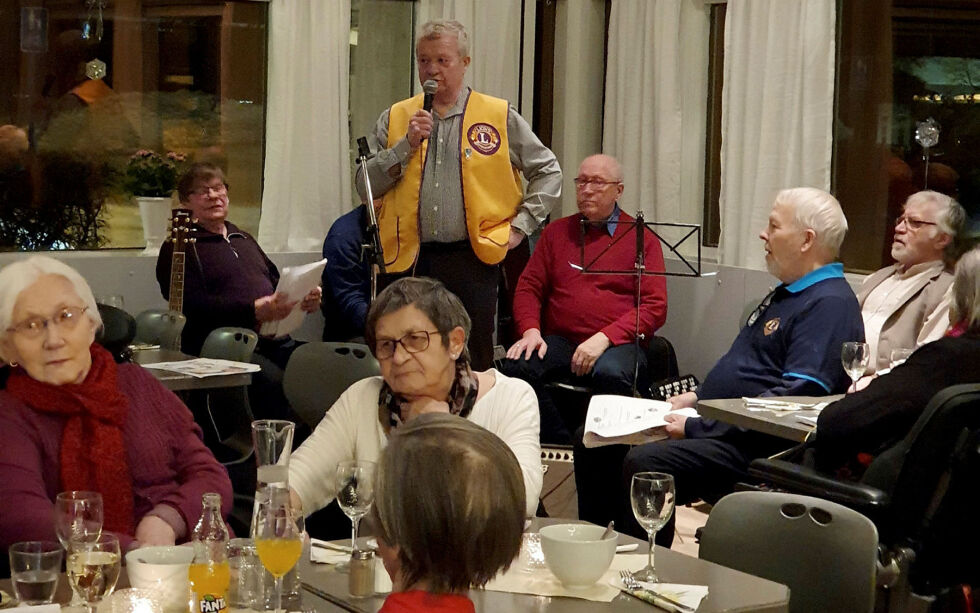 Leder i Lions Club Porsanger Ragnar Thomassen ønsker velkommen.
Sittende rundt ham er Gunvald Nilsen og Terje Olsen og medlemmer av Lakselv Spellemannnslag
 Foto: Evy Einarsen
