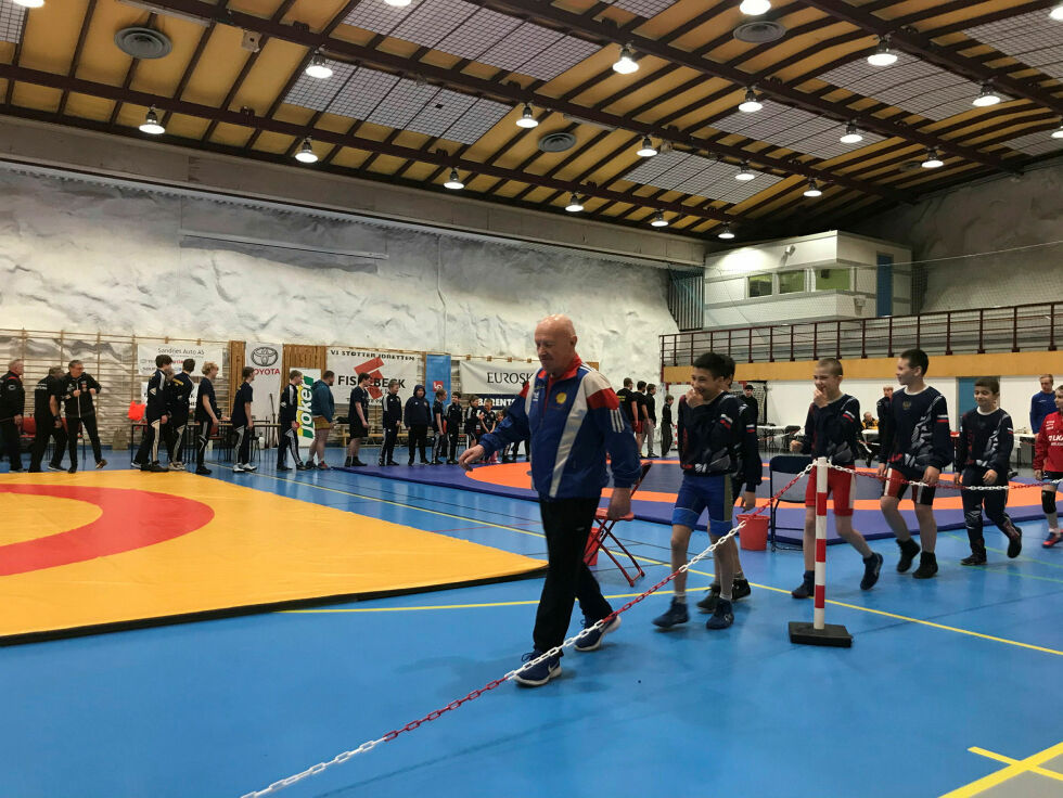 Oversiktsbilde av bryterne som introduseres i hallen øyeblikket før konkurransen starter. Willy Bangsund leder an.
 Foto: Nikita Møllersen