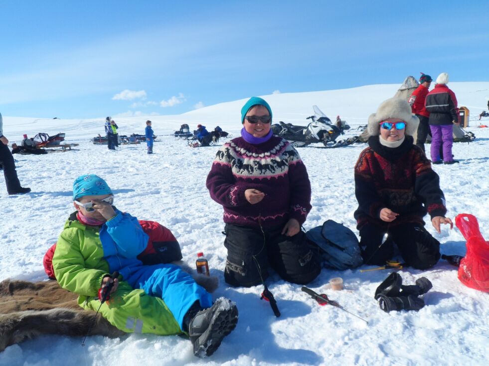 I år, som i fjor, er det meldt strålende vær under isfiskekonkurransen på Øvre Karlsvann. Her koser Camilla, Adrian og Malin Moeng seg i sola under fjorårets konkurranse.
 Foto: Lisbeth Myrvang