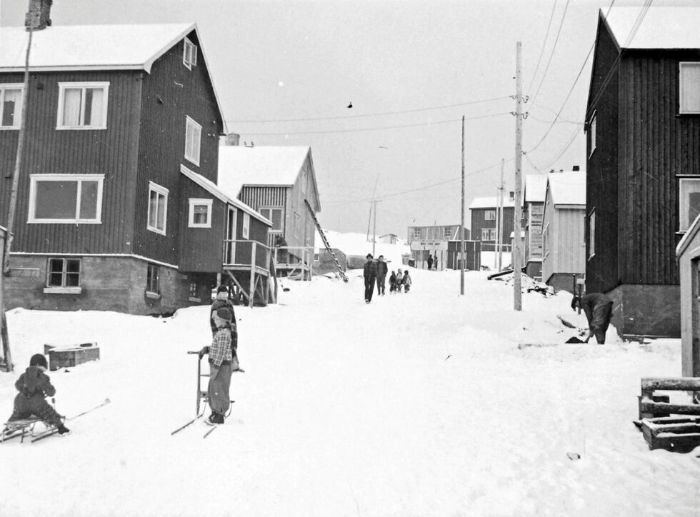 Mehamn, november 1947. Barn er ute med spark og kjelke i sneen. Permanente bolighus. Foto: Andreas Vodahl / Arkiv: Troms og Finnmark fylkesbibliotek