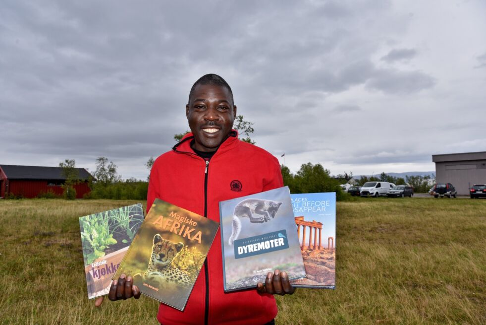 John Nsamba har et pent utvalg bøker med seg når han kjører rundt i Finnmark denne sommeren.
 Foto: Henriette Lille