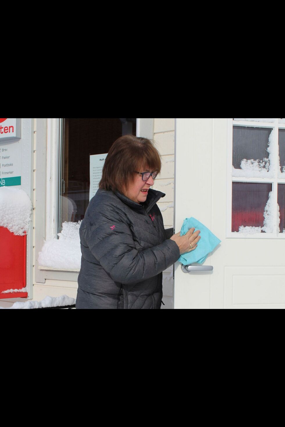 Rett før postens åpningstid renses dørhåndtakene, her er Eva Høiberget i gang. FOTO: RANDI IRENE LOSOA