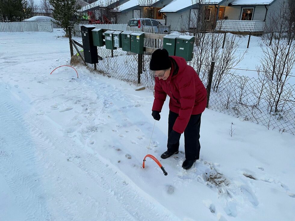 Andersen viser frem de lange fiberkablene og store steiner som ligger gjemt under sneen.
 Foto: Hannah Persen