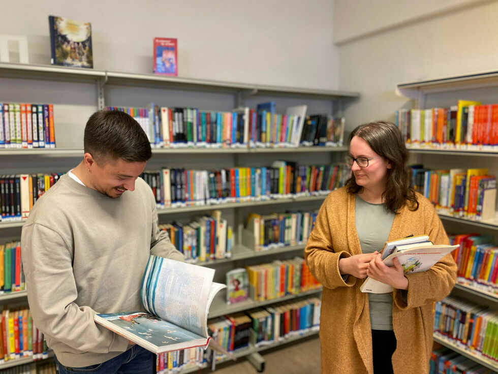 Biblioteksjef Espen Høybakken leter etter en katt i en av bøkene. Heli Korhonens initiativ blir godt mottatt av biblioteket i Porsanger.
 Foto: Roger Albrigtsen
