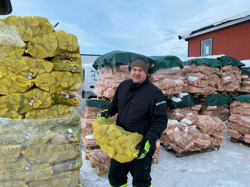 Her bærer Morten Kildemo hos Brenselutsalget i Kirkenes ut ved til kunder, men bedriften melder om noe mindre salg enn normalt i kulda.
 Foto: Hallgeir Henriksen