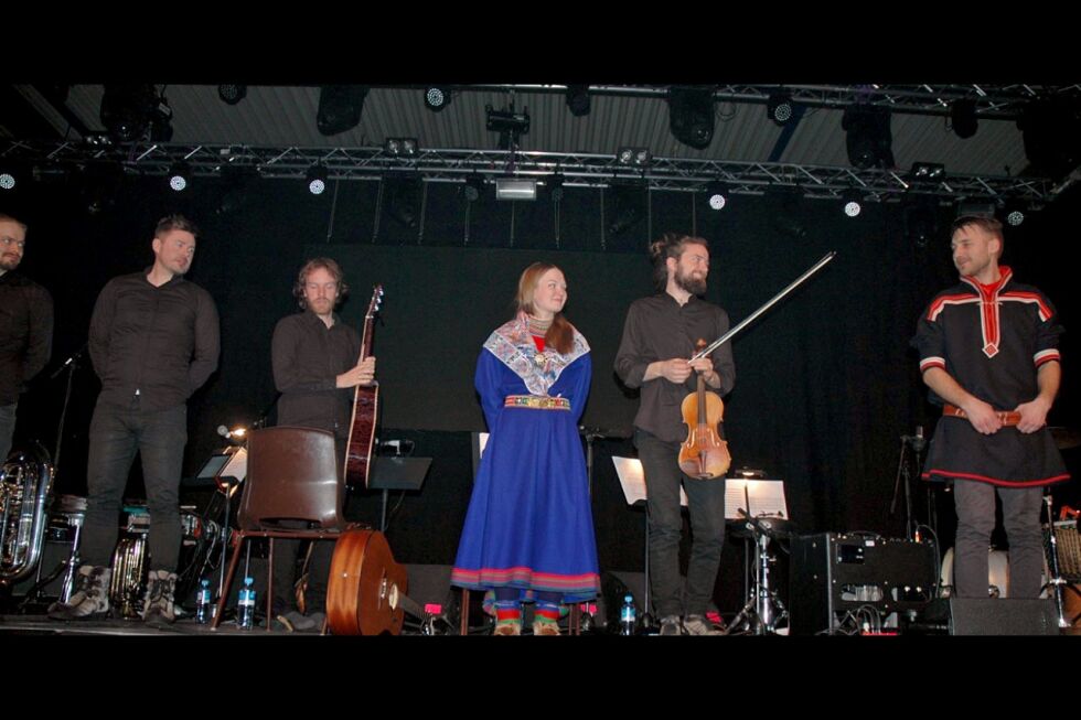 Veiviserensemblet, med Musikalsk leder Jakop Janssønn i kofte til høyre i bildet, sammen med Marja Mortensson og resten av Veiviserensemblet i Báktehárji under Samisk Påskefestival i Kautokeino.
 Foto: Rita Heitmann