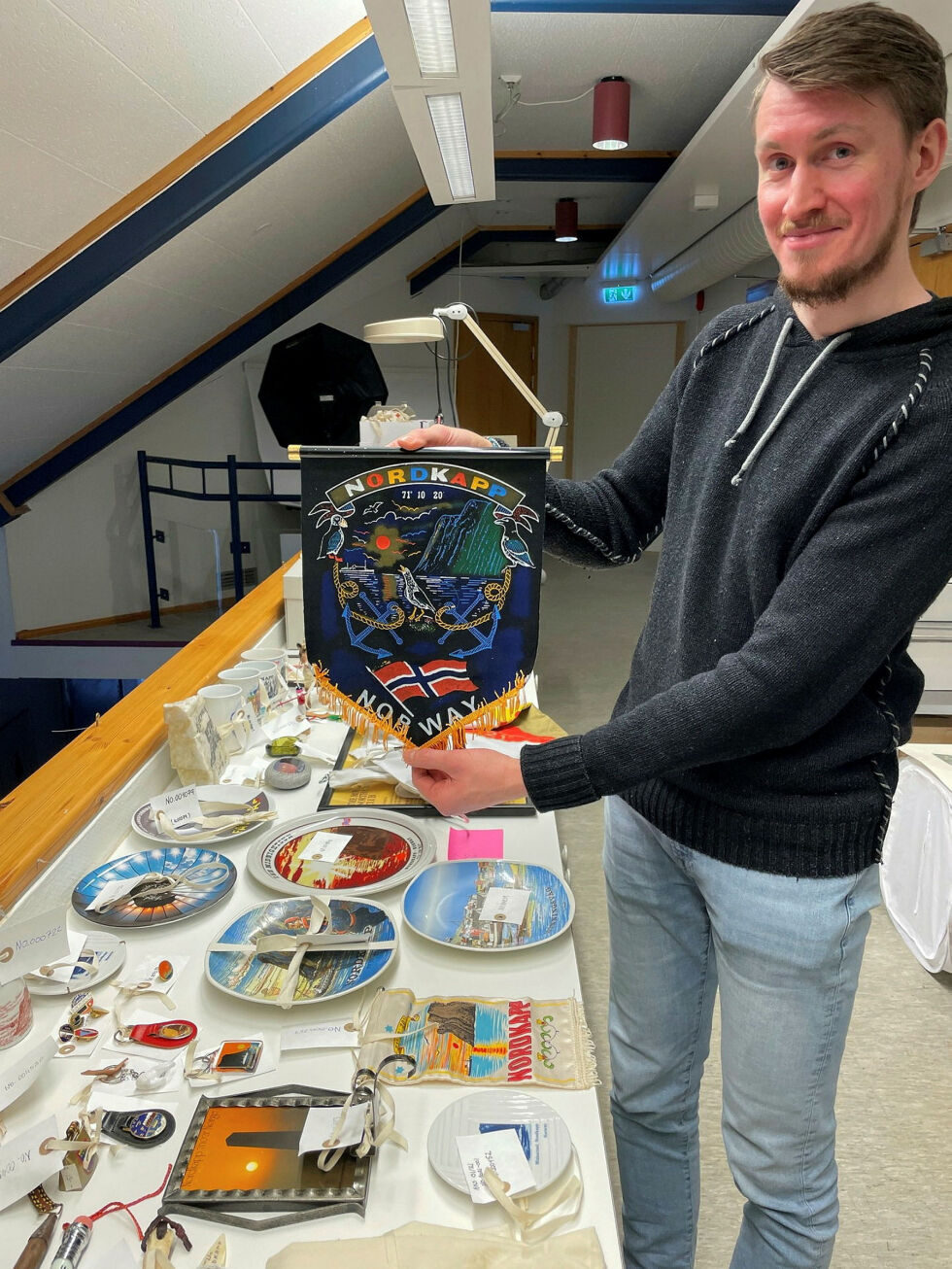 Nils Arne Fløystad er museumsmedarbeider med ansvar for forvaltning av Nordkappmuseets samlinger. Her viser han frem noe av det som museet har som viser Nordkapp-turismens historie.
 Foto: Nordkappmuseet