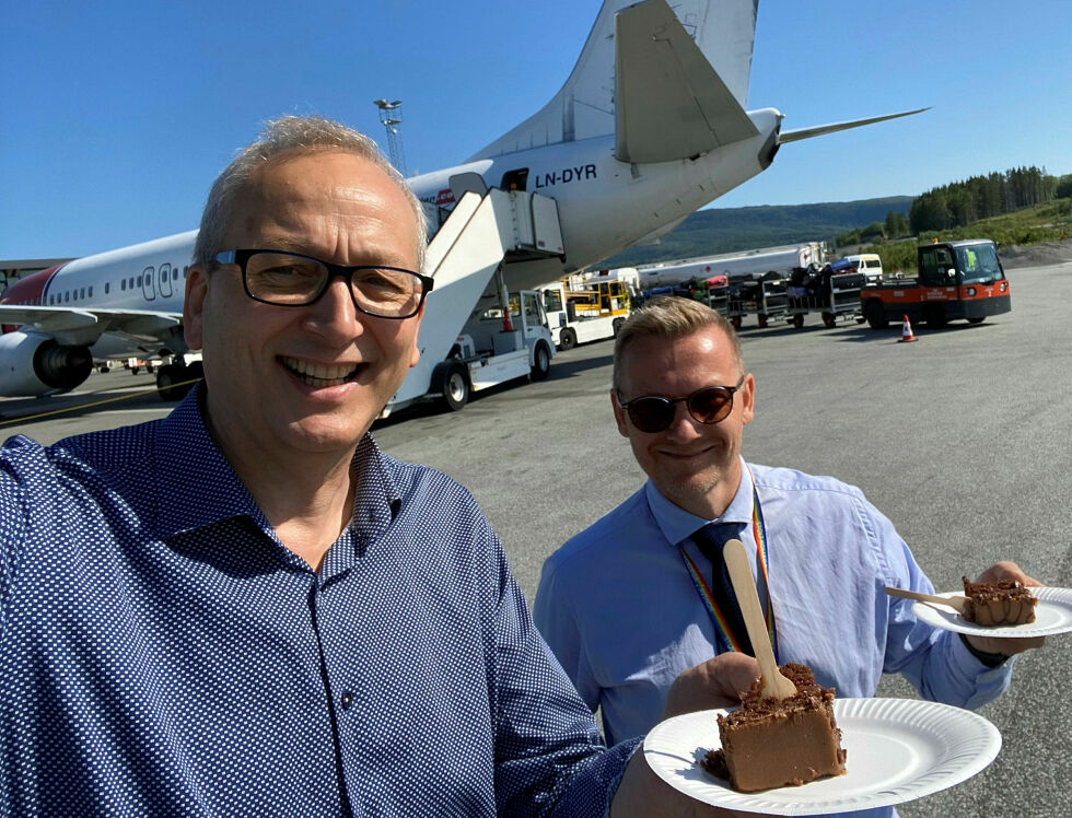 Evenes-ordfører Terje Bartholsen (til venstre) mener priskutt på flyreiser fortjener feiring. Her sammen med daværende lufthavnsjef på Evenes, Geir-Olav Skogstad, da 50-årsjubileet for Harstad/Narvik lufthavn Evenes ble feiret med kake sommeren 2023.
 Foto: Selfie