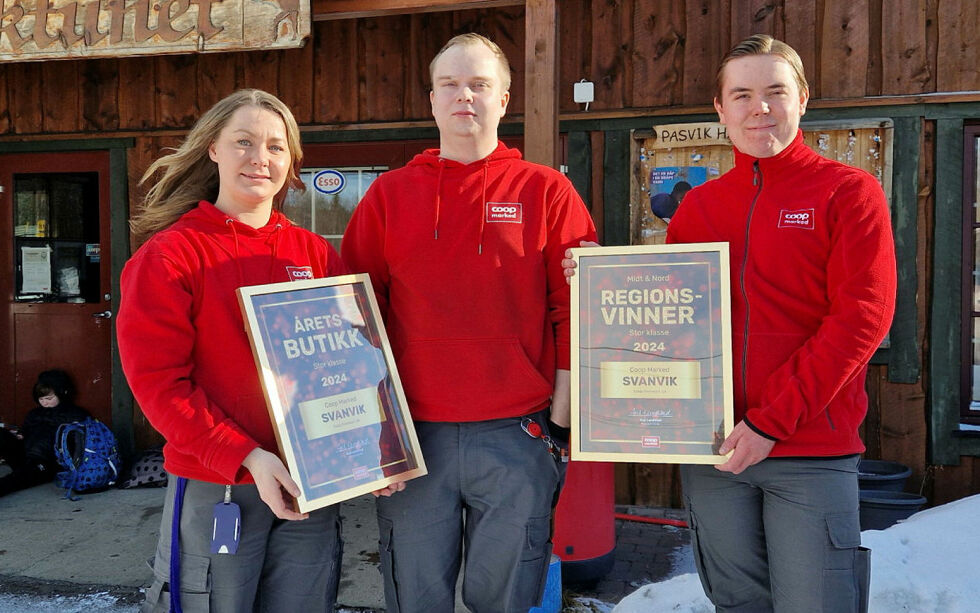 Teamet i Coop Marked Svanvik viser plakettene med årets butikk og regionvinner.
 Foto: Hill Haga