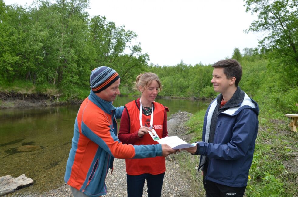 Sørum Nymo fikk overrakt fiskekort av grunneierforeningens leder Kai-Simon Johansen. Sandrine Bocher Johansen så til at alt gikk ordentlig for seg.
 Foto: Roger Albrigtsen