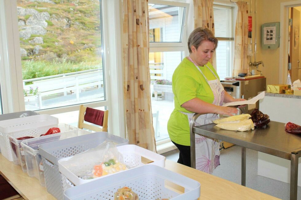 Janne Ebeltof Johansen, sykepleier på Bugøynes omsorgssenter, bruker fridagen sin på matlaging på senteret, i Bugøynes helselags regi. I forgrunnen ser vi ferdige middagsretter som kjøres dit fra Kirkenes. Tidligere ble middagen laget på senterets kjøkken.