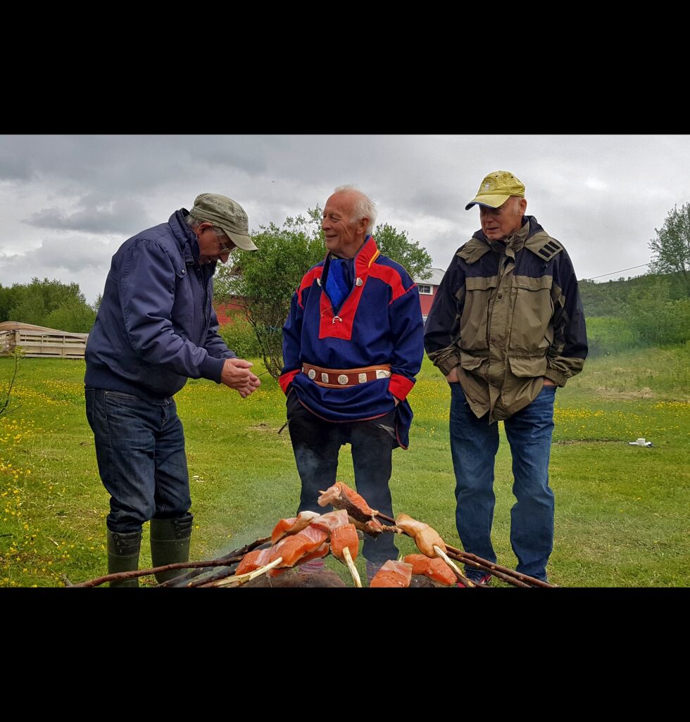 Sannsynligvis en laksehistorie som er samtaleemne rundt laksespidd-bålet i pausen. Fra venstre Johannes Varsi, Andreas Njarga og Randolf Knotten.
 Foto: Trine Sveinsdatter Johansen