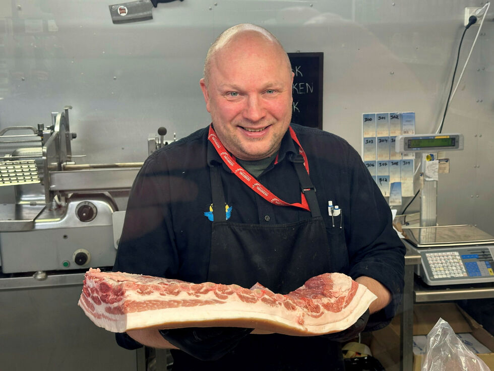 Kjøpmann Jari Kekäle på Nord1Market i finsk Njäuddâm viser her frem et prakteksemplar av ei ribbe, som vil kunne bli herlig julemiddag, takket være nok fett under svoren.
 Foto: Hallgeir Henriksen