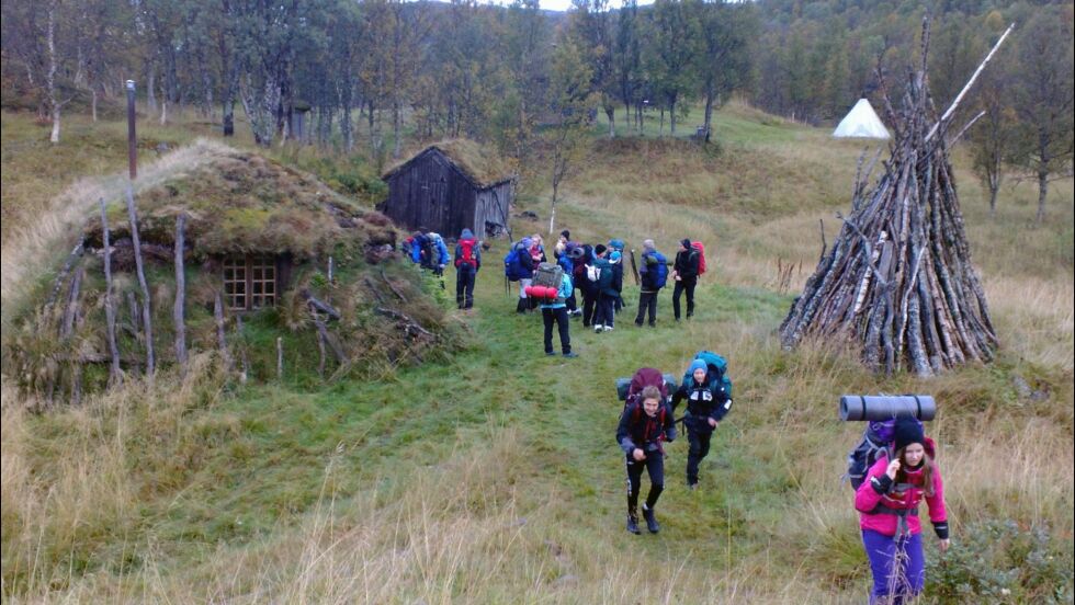 Vilgesvárre er et populært utfartssted, og arena for læring. Her er en skoleklasse på tur hjem etter en aktiv dag i markasamisk historie. Til venstre Olagammen; øvrige bygg skimtes i bakgrunnen.
 Foto: Vilgesvárre