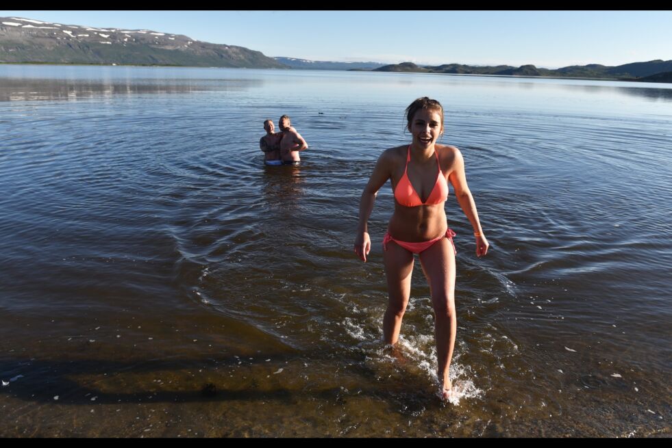 Sarah Straumsgaard (22) fra Tromsø var fornøyd etter midnattsbadingen. Her med Mikael Gaare og Esten Evensen fra Honningsvåg i bakgrunnen.
 Foto: Sigurd Schanke
