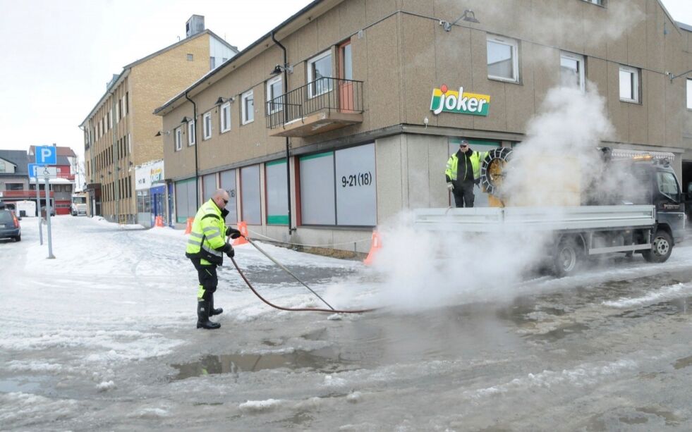 Her åpner Bent-Lasse Hansen en kumme ved Joker i Kirkenes, mens Tom Mietinen, begge i kommunens teknisk etat, stimer en frossen kumme, slik at vannet kan renne fritt ned i denne. Foto: Hallgeir Henriksen