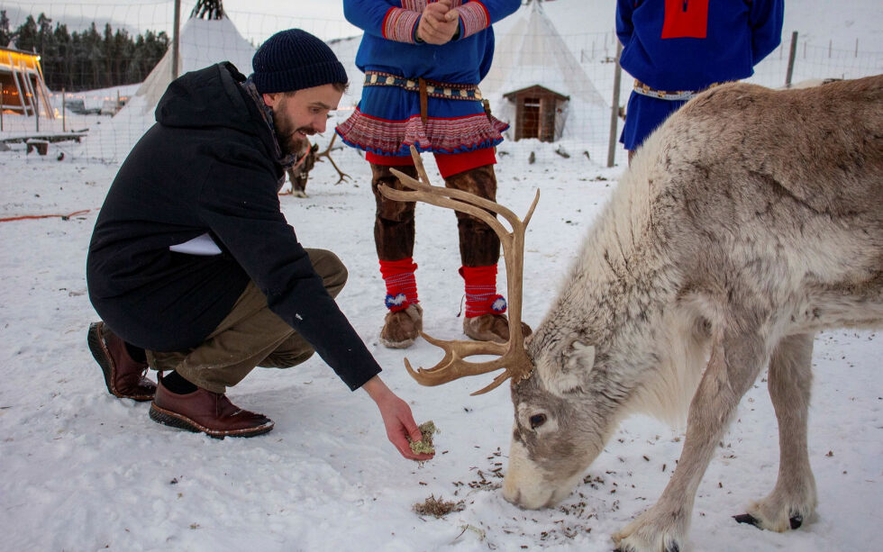 Næringsminister Jan Christian Vestre mater reinsdyr under et besøk på opplevelsessenteret Sami Siida i Alta.