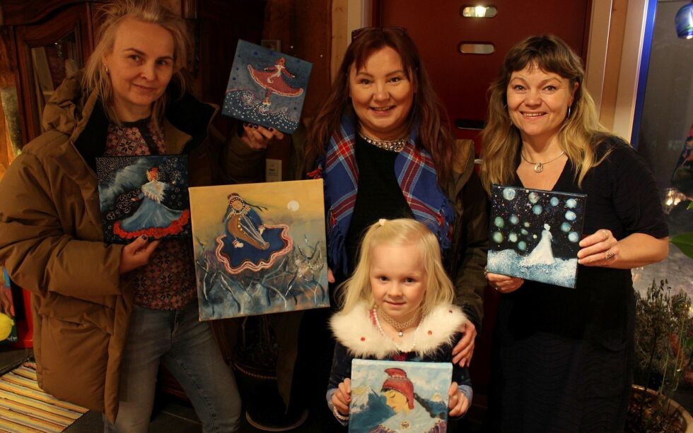 Ce­li­ne Joks-Myr­voll på fem og et halvt år poserer med de samiske prinsessemaleriene til Ellen Brita Anti (i midten). Til venstre ser vi mora Hege Joks, mens kunstner Sigrid Larsen står til høyre på bildet.
 Foto: Elise Embla Scheele
