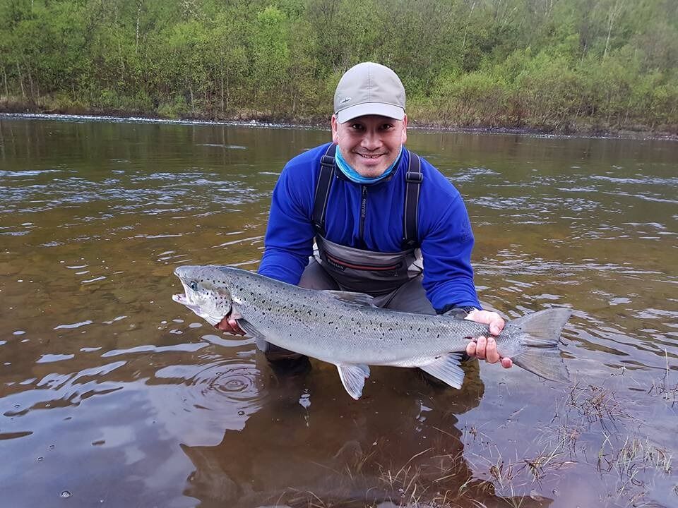 En time inn i det første fiskedøgnet fikk Vinh Trinh denne laksen på kroken i Lakselva. Ikke rart han smiler bredt!
 Foto: Egil Liberg, daglig leder i Lakselv Grunneierforening